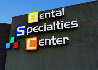 Picture of finished wall sign for dental office, consisting of different colored boxes and letters.
