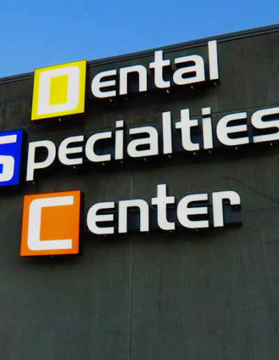 Picture of Dental Center sign lit up at night.