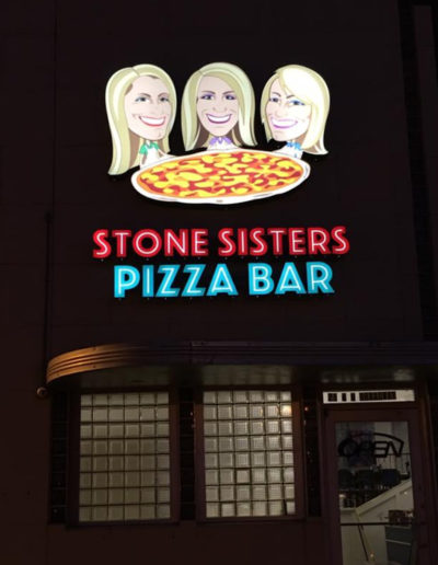 Nighttime picture of Stone Sister's Exterior Sign.