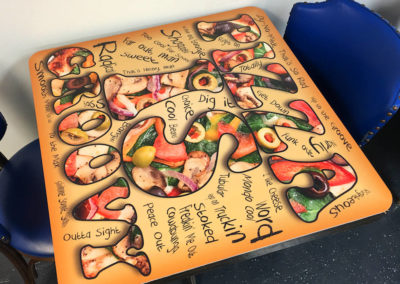 Picture of custom table top graphics with groovy and cool words in a colorful layout.